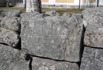 Stenmur med bokmärken inristade