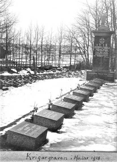 Ett högt monument över de stupade och nedanför gravstenar liggande i en rad framför