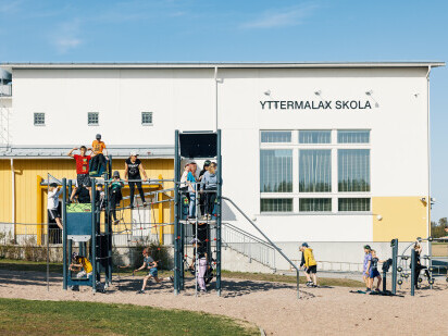 Yttermalax skolan oppilaat leikkivät kiipeilytelineessä.