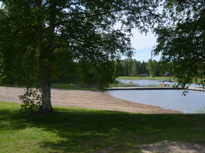 Sandstrand och flytbrygga.