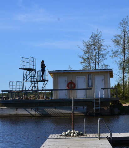 Bild av hopptornet i Åminne. På hopptornet står en kvinna.